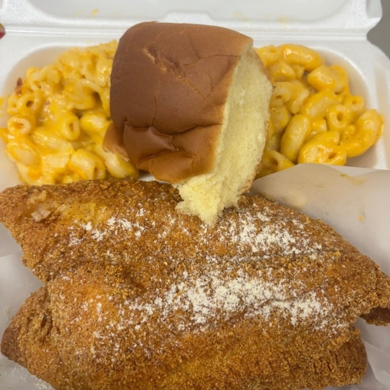 A delicious 2-piece catfish meal featuring golden, crispy fried catfish served with warm cornbread and creamy macaroni and cheese, perfect for soul food lovers.