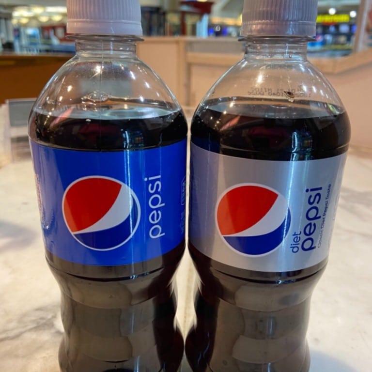 Two bottles of Pepsi soda on a table at Corine's Cakes & Catering, showcasing popular beverage options.