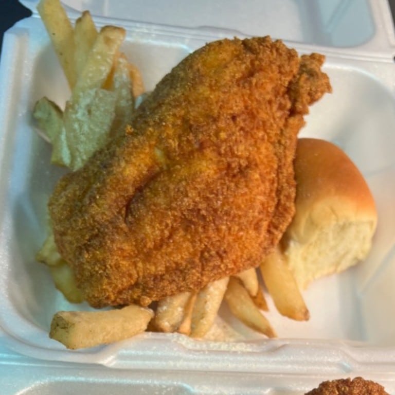 Crispy fried catfish served with French fries and a soft bread roll, perfect for a Southern-style meal at Corine's Soul Food.