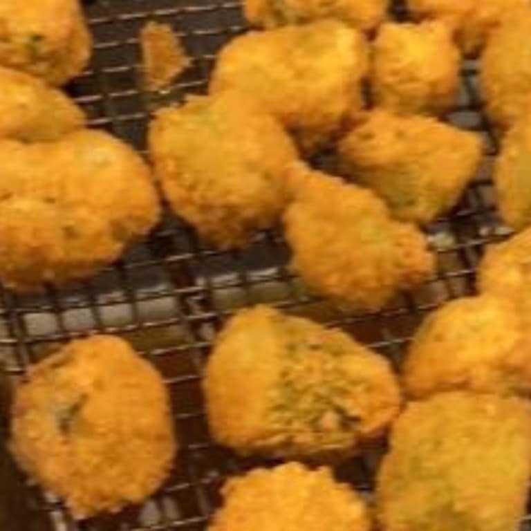 Crispy fried okra pieces on a cooling rack, showcasing Southern-style soul food. Perfectly golden and crunchy, ideal for catering or family meals.