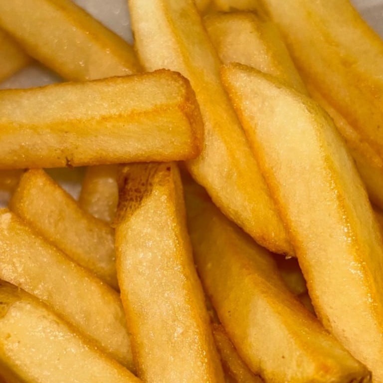 Crispy golden French fries served fresh, perfect for a savory snack or side dish at Corine's Soul Food, Cakes & Catering.