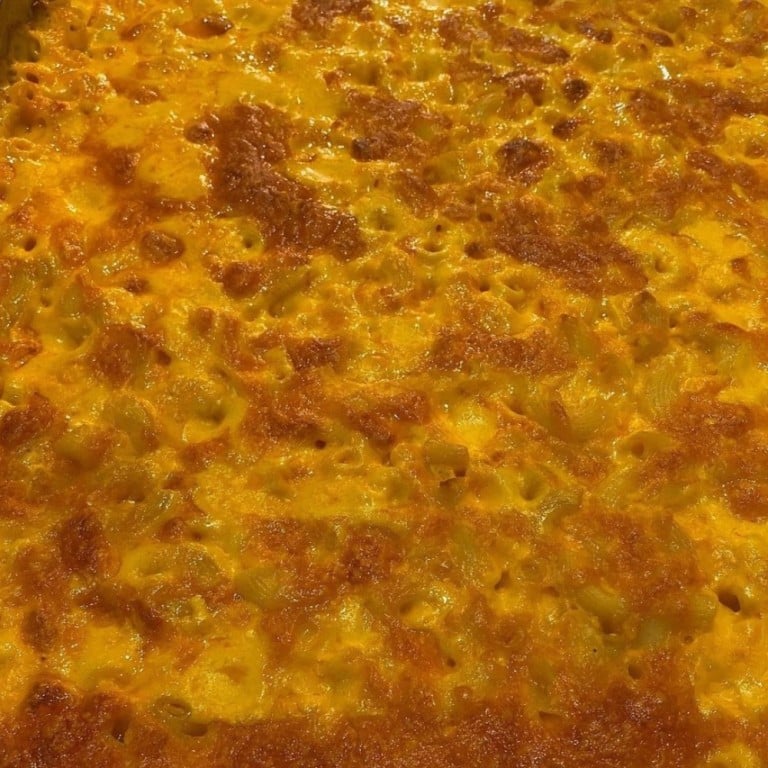 Delicious baked macaroni and cheese featuring creamy cheese sauce and golden crispy topping, perfect for soul food lovers and catering events.