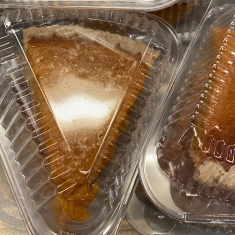 Delicious homemade sweet potato pie in clear plastic container, showcasing a golden-brown crust and smooth filling, perfect for dessert or special occasions.