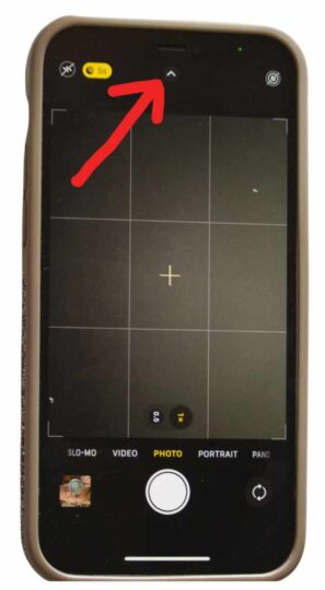 Smartphone screen with a red arrow pointing at the top of the screen.