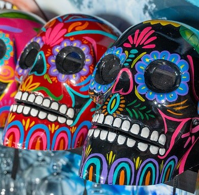 Vibrant sugar skull helmets with floral designs for motorcycle safety and style.