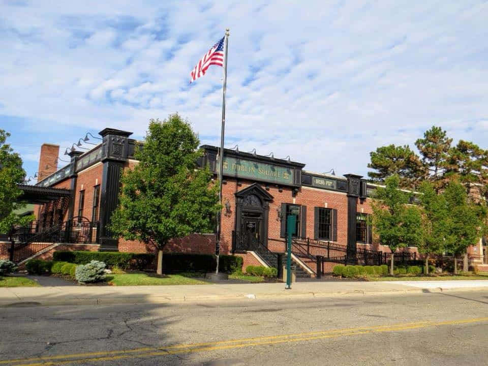 Historic Dublin Square building with American flag and trees.