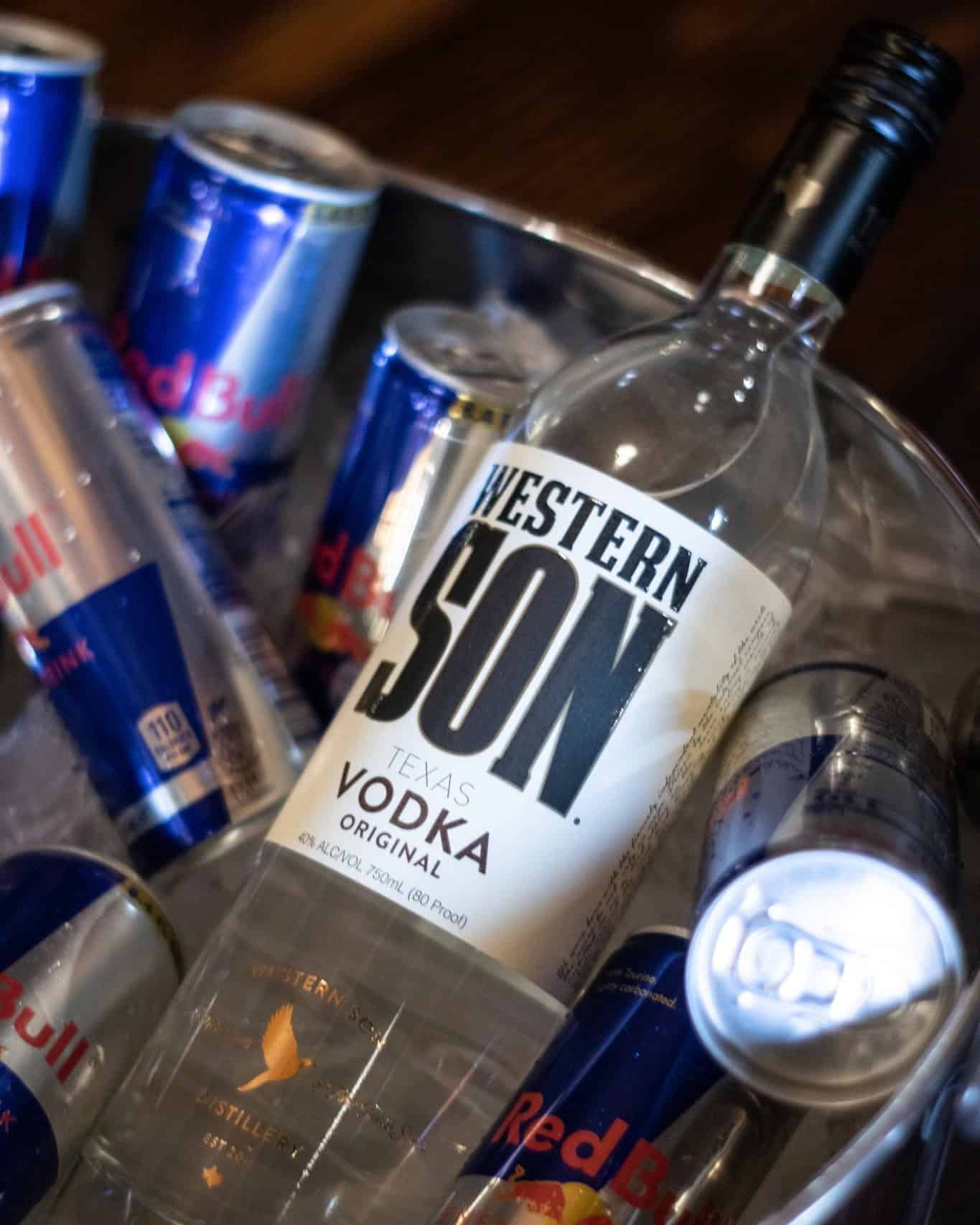 Bottle of Western Son vodka with Red Bull cans in a cooler.