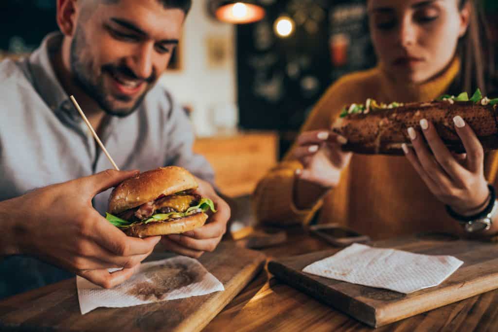 Two people enjoying sandwiches and panini at Dublin Square in Lansing.