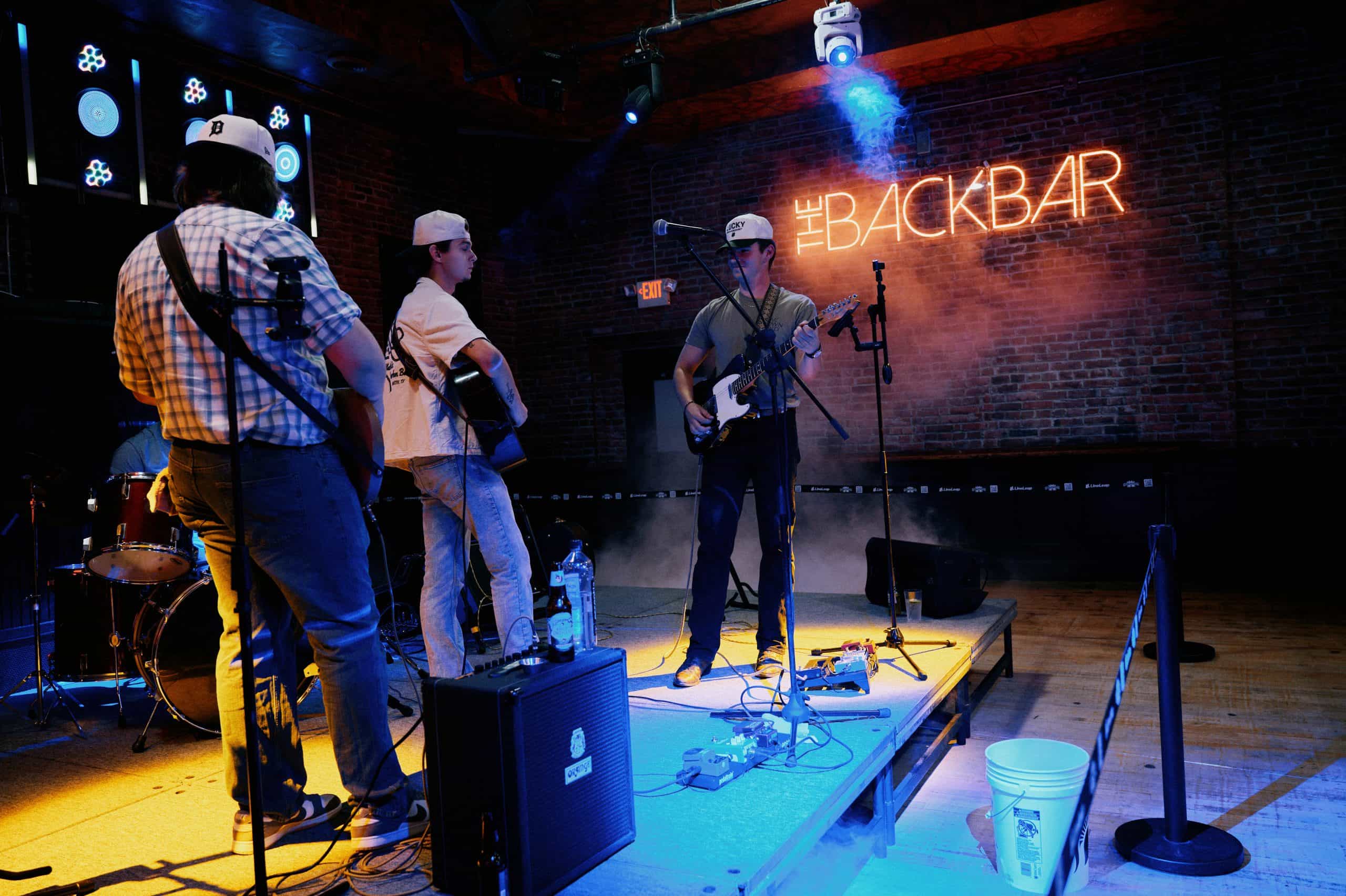Live band performing at Dublin Square with neon sign backdrop.