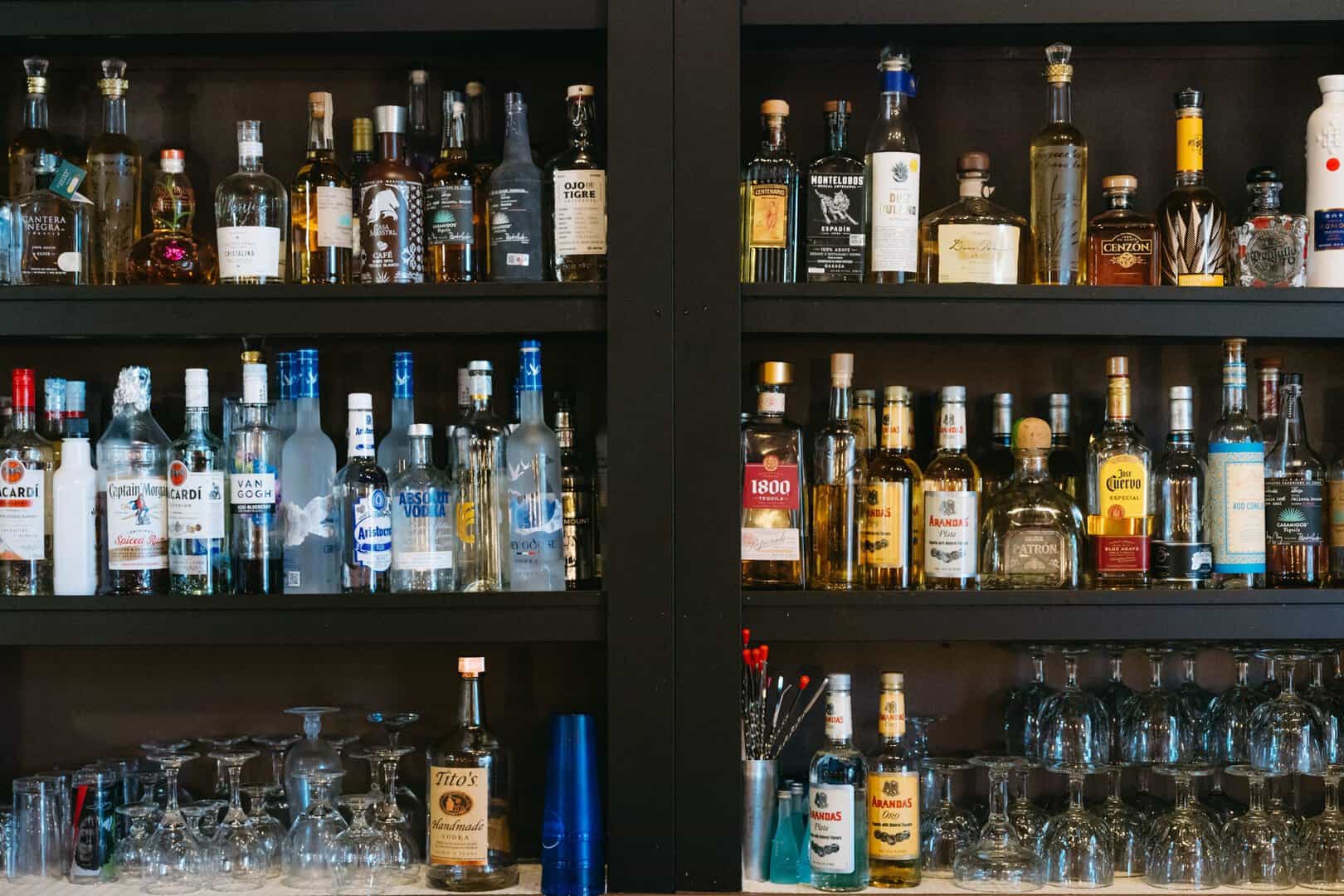 Bar shelves with various liquor bottles and glasses at El Burrito Loco.