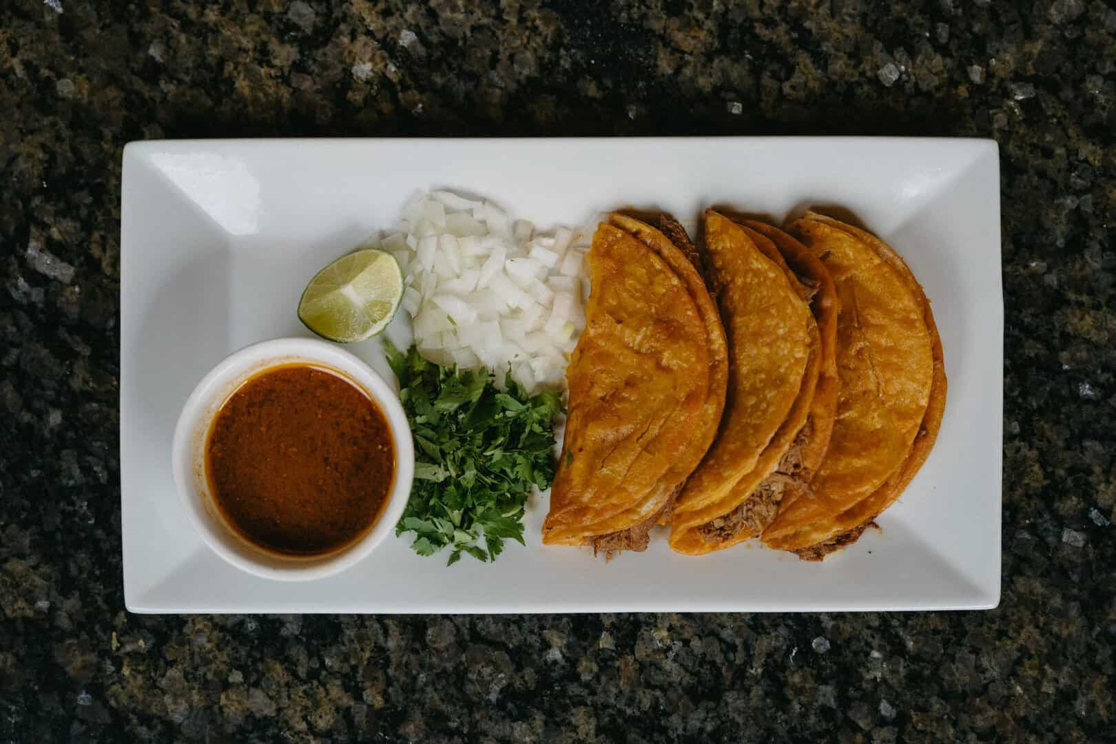 Authentic Mexican tacos with onions, cilantro, and salsa at El Burrito Loco.