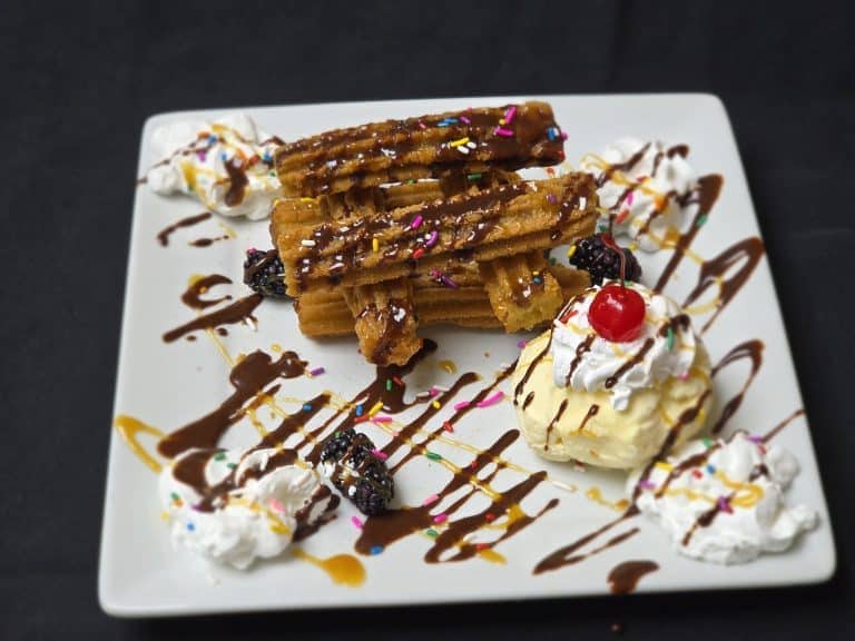 Delicious dessert with waffles, whipped cream, berries, and chocolate drizzle.