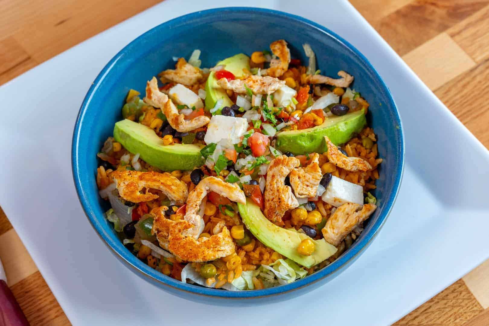 Colorful Mexican rice bowl with chicken, avocado, and vegetables at El Mesquite.