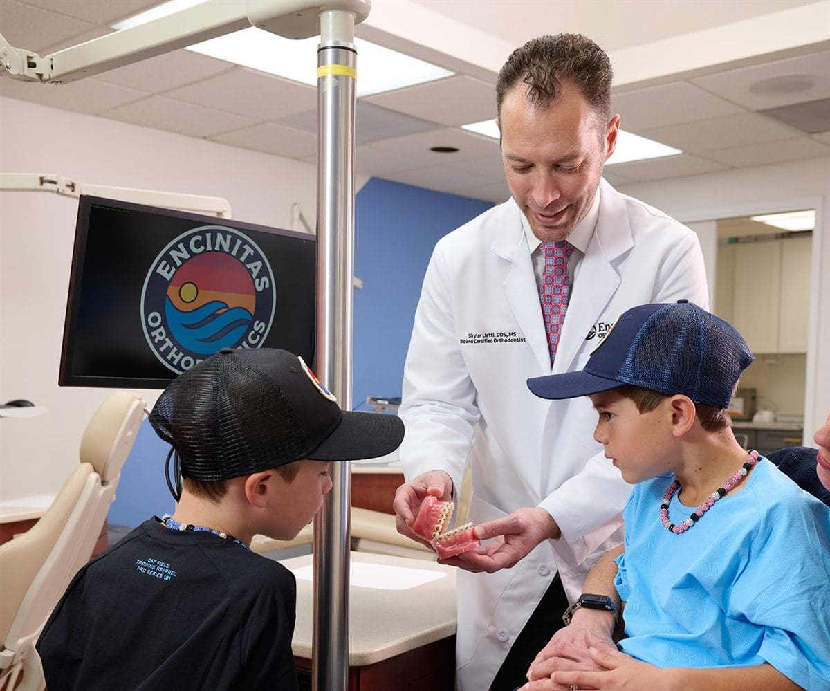 Dr. Liatti showing a demonstration model of braces to two young patients