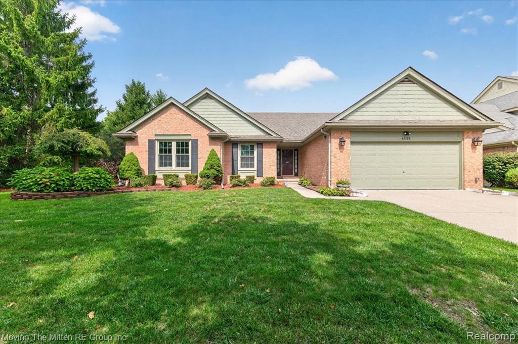 Brick exterior with shuttered windows, attached two-car garage, concrete driveway, and front landscaping