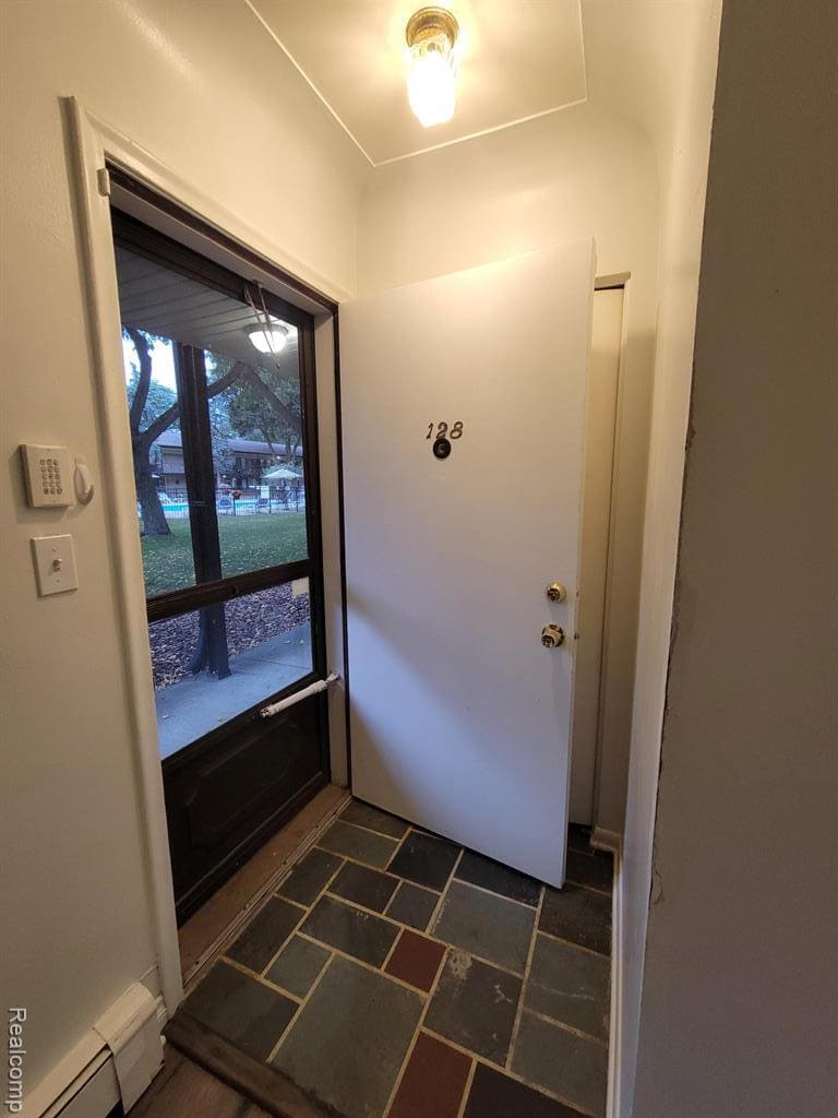 Brick exterior with a storm door and a multi-pane sliding window