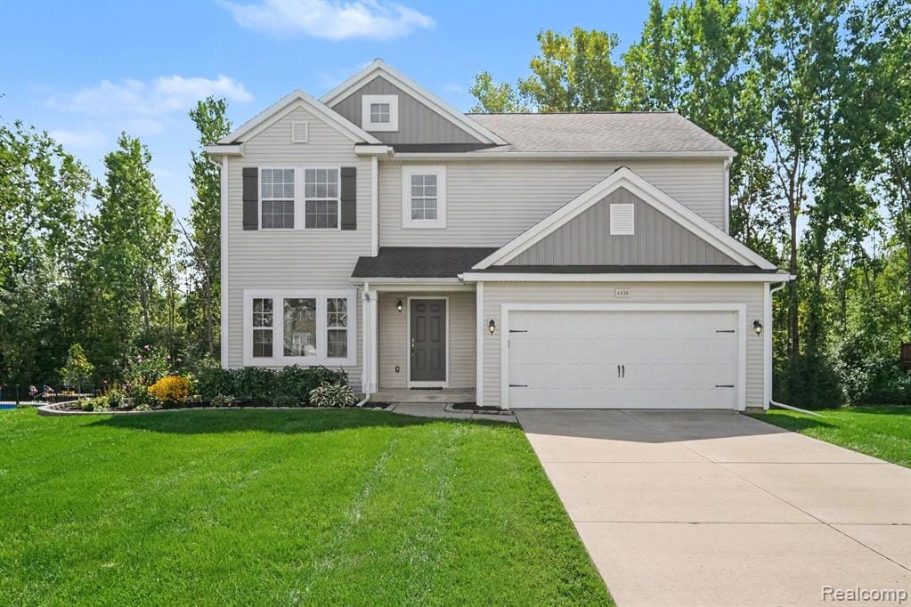 Two-story residence featuring light-toned siding, dark shutters, an attached two-car garage, established landscaping, and a concrete driveway