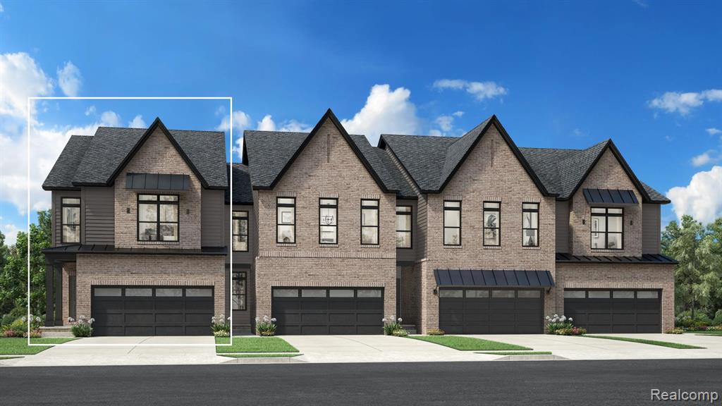View of front of property featuring a garage, driveway, and brick siding