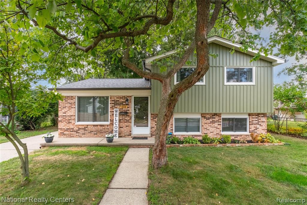 Brick and vertical siding exterior with mature trees