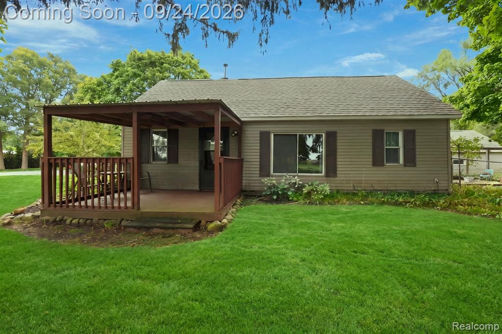 Side-gabled residence with light brown siding, dark brown window shutters, and a covered porch