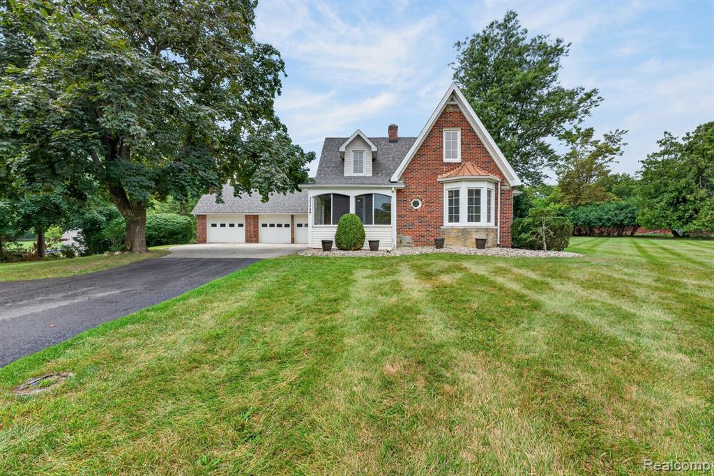 This distinctive brick Tudor on the banks of the Huron River makes an impressive first impression with steeply pitched gable, gracious covered front porch with original oak plank ceiling and timeless architectural details. And while the character is classic, a two story addition in 2000 brought the space and modern conveniences today’s buyers appreciate. With 4 bedrooms, 2 full and 1 half bath, a 3-car garage, and nearly 2.5 acres spread across three lots, there’s room to play, garden, entertain—and simply enjoy the peace and quiet. Even better, no flood insurance is required. The home has been removed from the flood zone. Major updates include two newer furnaces (2022 and 2025), roof (2022), sump pump (2026), fireplace converted to gas (2023) and asphalt driveway (2026). Updated vinyl casement windows allow for a generous cross breeze, and updated electrical for peace of mind.  The kitchen was remodeled in 2021 with quartz countertops, farmhouse sink, appliances & recessed lighting. All 3 upstairs bedrooms feature walk-in closets as well as a bonus cedar closet. The main-floor primary suite is a massive retreat with a private full bath, two walk-in closets and a doorwall leading to the expansive deck. Main-floor laundry room makes everyday living a lot easier. And then there’s the backyard. Calling it “park-like” almost doesn’t do it justice. Your own private nature preserve, where deer/wildlife wander & bald eagles make appearances. Enjoy the above-ground pool, relax on the deck, or grab your fishing poles and head to the river’s edge. The west peninsula provides a sandy beach area. The peaceful river setting creates a backdrop that’s hard to replicate—and the city-maintained seawall is one less thing for you to worry about. The generous grounds provide peaceful living. Close to everything! Less than 1 mile from Downtown Flat Rock, minutes from I-275, & 15 min to Detroit Metro Airport. This one is anything but ordinary. Seller has C of O in hand for the buyer!