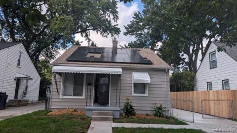 Front exterior with solar panels, light-colored siding, and a covered porch