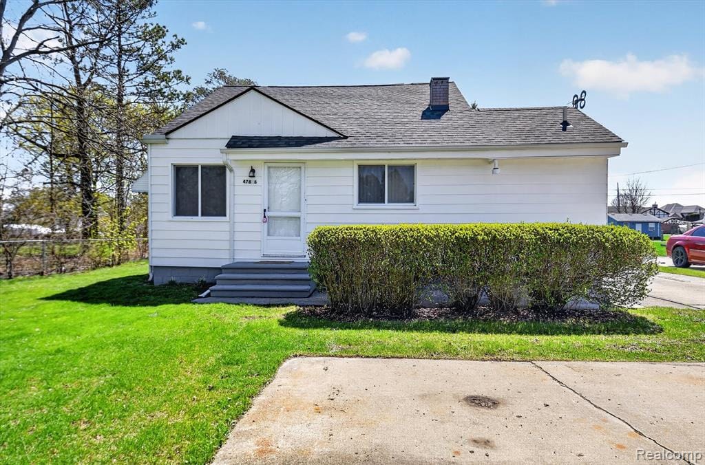 View of front of home with a shingled roof, a chimney, and entry steps