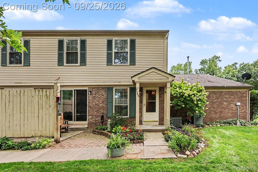 Two-story property featuring horizontal siding, brick accents, and a covered entry