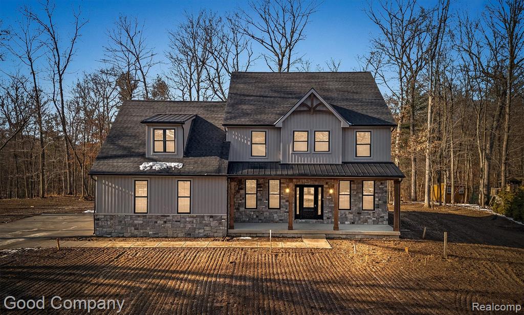 Ground has broken on this extraordinary home. Delivery February 2027. Home in photos is a similar home recently completed. 2,769 square foot waterfront Colonial situated on a spectacular 6.88  acre lot in White Lake Township. The setting is incomparable - with acres to enjoy on the private peninsula overlooking the tranquil lake. This residence offers 3 generous bedrooms, 2 1/2 ceramic tile baths, and an oversized bonus room on the upper level.  The open-concept first floor features 9’ ceilings, 8’ two-panel doors, 6” baseboards, and Abode by Kentwood engineered hardwood flooring throughout the main level and primary bedroom. A custom open poplar staircase with wrought iron spindles creates a striking architectural focal point. The kitchen is appointed with custom Lafata maple cabinetry, granite countertops, under-mount sinks, and Delta or Kohler plumbing fixtures. A direct-vent gas fireplace anchors the main living space. Exterior finishes include a brick front with Michigan brick detailing, CertainTeed board and batten with horizontal siding, Landmark dimensional shingles, and standing seam metal roof accents. A 3-car side-entry garage with 8’ insulated doors enhances both function and curb appeal. An 8’ Therma-Tru entry door with sidelights and Pella or Andersen windows provide both performance and aesthetic appeal. Covered front and rear porches feature tongue-and-groove pine ceilings, with the rear terrace prepped for a wall-mounted exterior TV. Built with 2x6 exterior wall construction, R-21 insulation, 9’ poured concrete basement walls, and plumbing prep for a future bath and bar. High-efficiency furnace and A/C with humidifier, LED lighting throughout, generator-ready disconnect, sod, and sprinklers complete the package. A rare waterfront offering with elevated finishes and exceptional build quality.