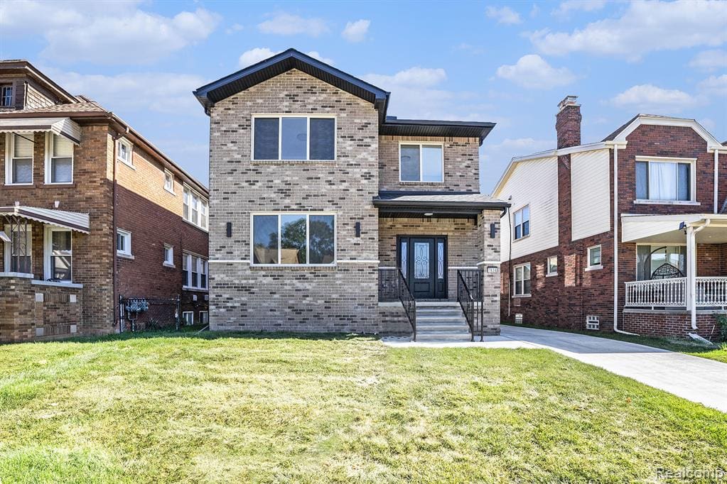 View of front of property with brick siding and a front lawn