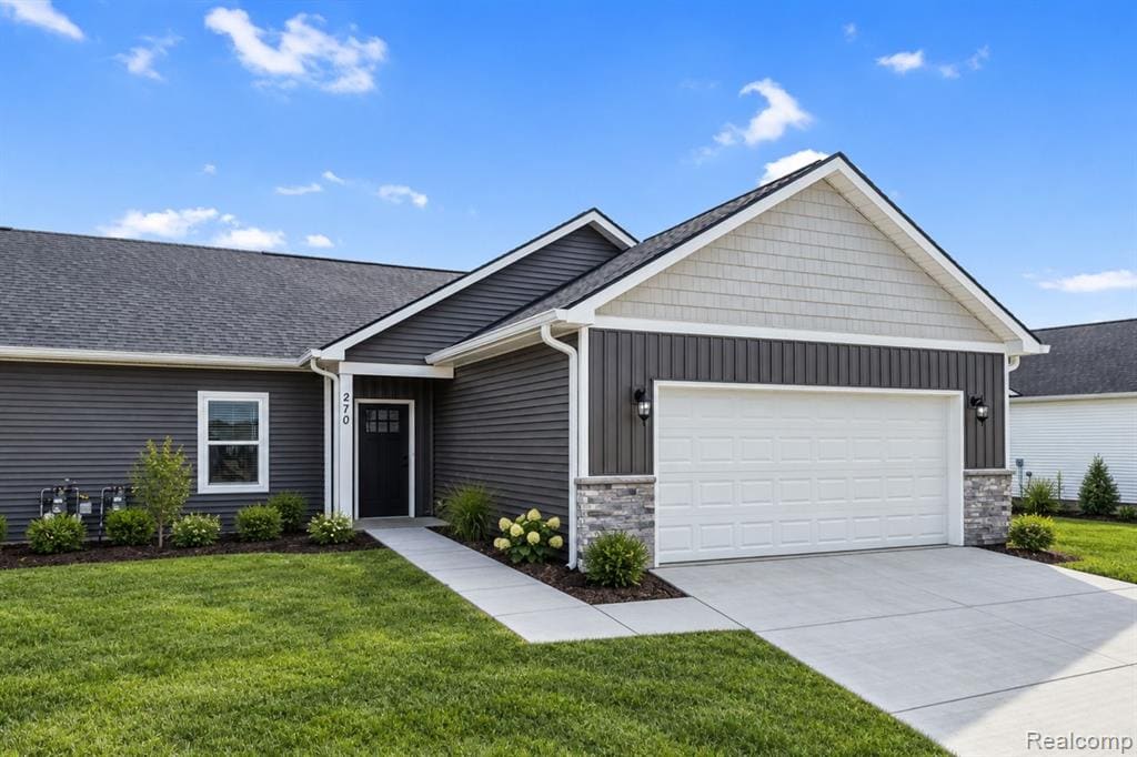 Exterior featuring dark gray horizontal siding, a white paneled garage door, a front door with lites, and stone accent pillars