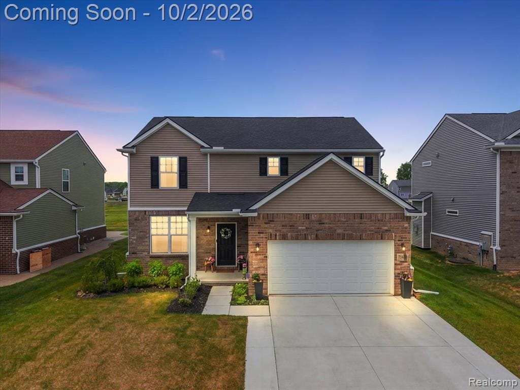 Two-story residence featuring a brick and siding exterior with a two-car garage