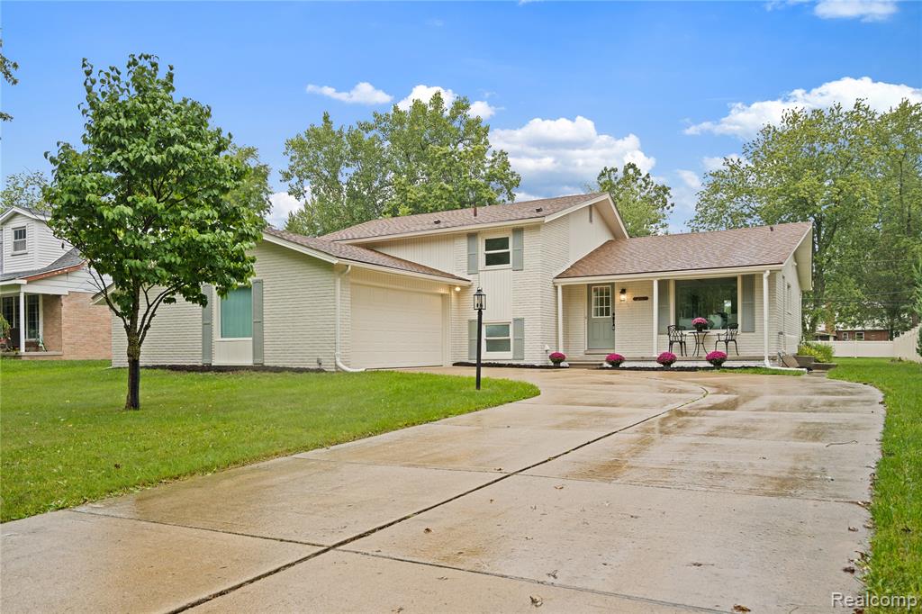Exterior featuring a covered entryway, attached garage, and a concrete driveway