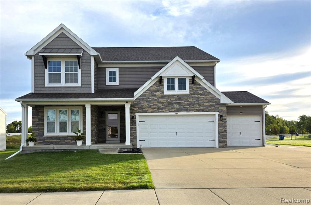 Two-story residence featuring a mixed material exterior with stone and siding, a covered front porch with white columns, and a multi-car garage with white doors