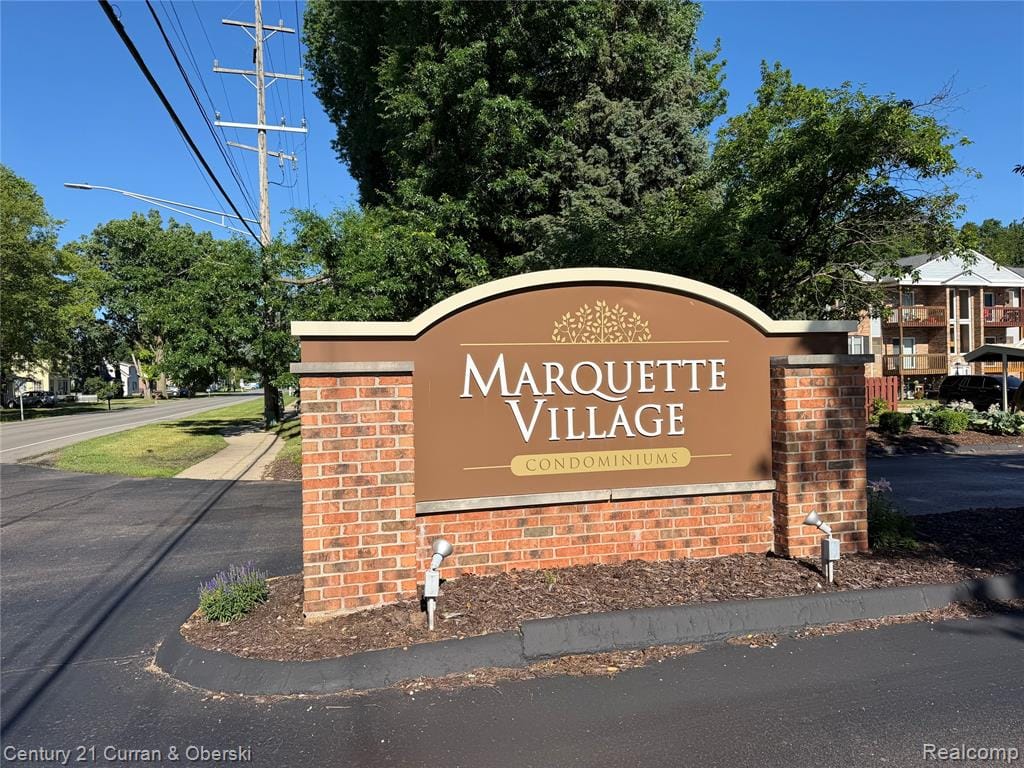 Marquette Village Condominiums entrance sign with brick base and integrated spotlighting