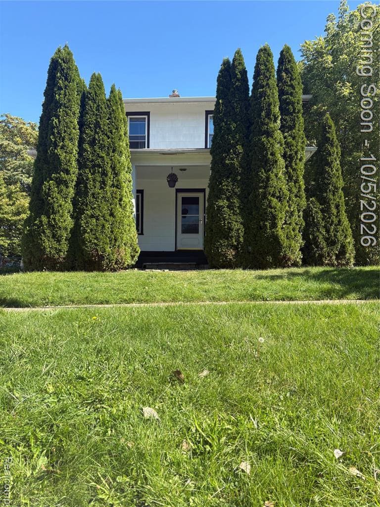 Charming two-story residence framed by mature evergreen landscaping and expansive manicured lawn