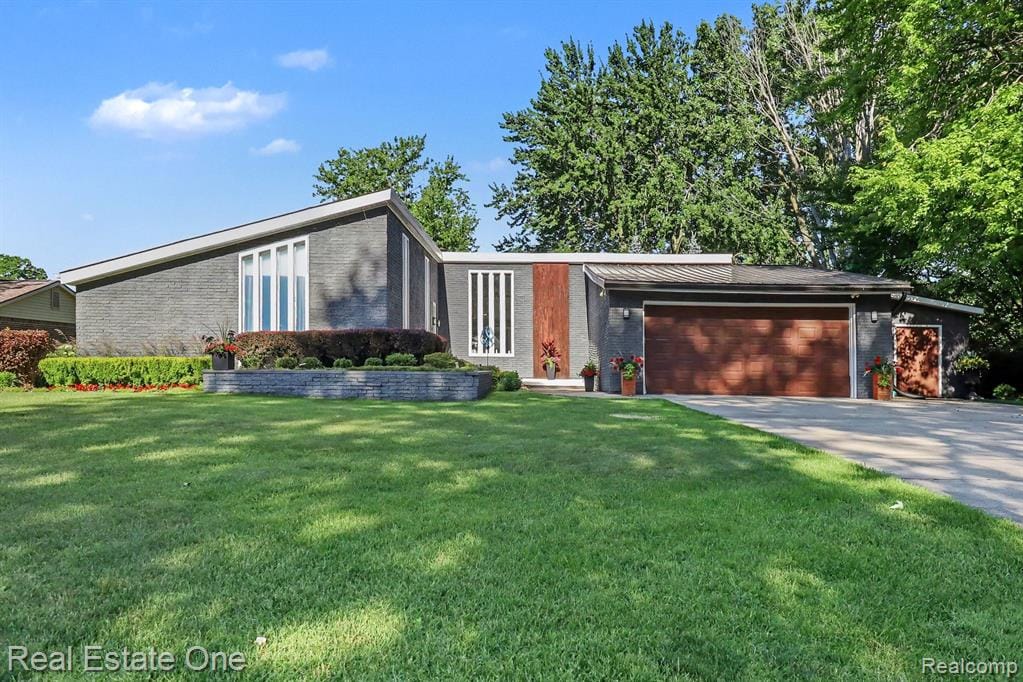 Mid-century modern residence featuring a dark gray brick exterior, a striking angular roofline, and a wide concrete driveway