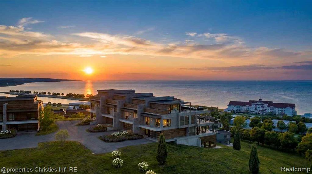 Rising above Little Traverse Bay, The Summit Over Bay Harbor offers a rare opportunity to create a bespoke waterfront residence in one of Northern Michigan’s most prestigious resort settings. Designed for those who value elevated living, privacy, and unforgettable surroundings, each residence captures sweeping water views and dramatic sunsets from multiple levels.This expansive offering features approximately 5,078 square feet of interior living space, complemented by a 598 square foot rooftop terrace designed for entertaining, relaxation, and evening gatherings overlooking Lake Michigan. Floor-to-ceiling windows flood the interiors with natural light and frame the bay as a living work of art. The main living level is ideal for hosting, anchored by a gourmet kitchen, premium appliances, generous island, fireplace, wet bar, and private balcony suspended above the water.The primary suite is a serene retreat with panoramic views, balcony access, a spacious walk-in closet, and spa-inspired bath. The walkout lower level provides an en-suite guest bedroom, family room, bar area, office, and private patio, creating effortless flow for entertaining and extended stays.Residences at The Summit Over Bay Harbor are offered as custom build opportunities, allowing buyers to select architectural details, interior finishes, and premium upgrades tailored to their lifestyle. Located across from The Cliffs at Bay Harbor and minutes from Petoskey, Charlevoix, Boyne City, and Harbor Springs, this is Northern Michigan luxury living at its finest.