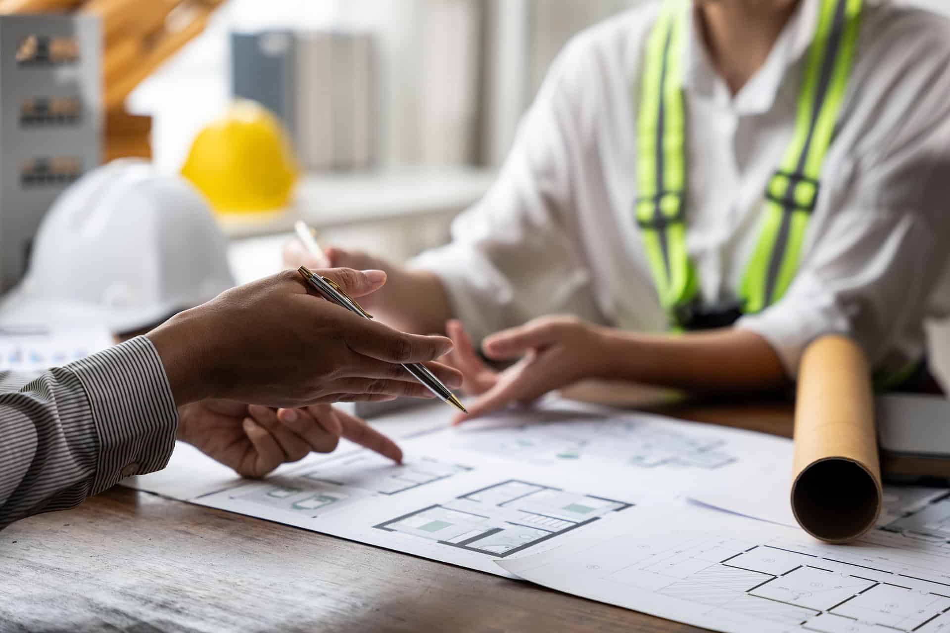 People reviewing home plans and permit documents.