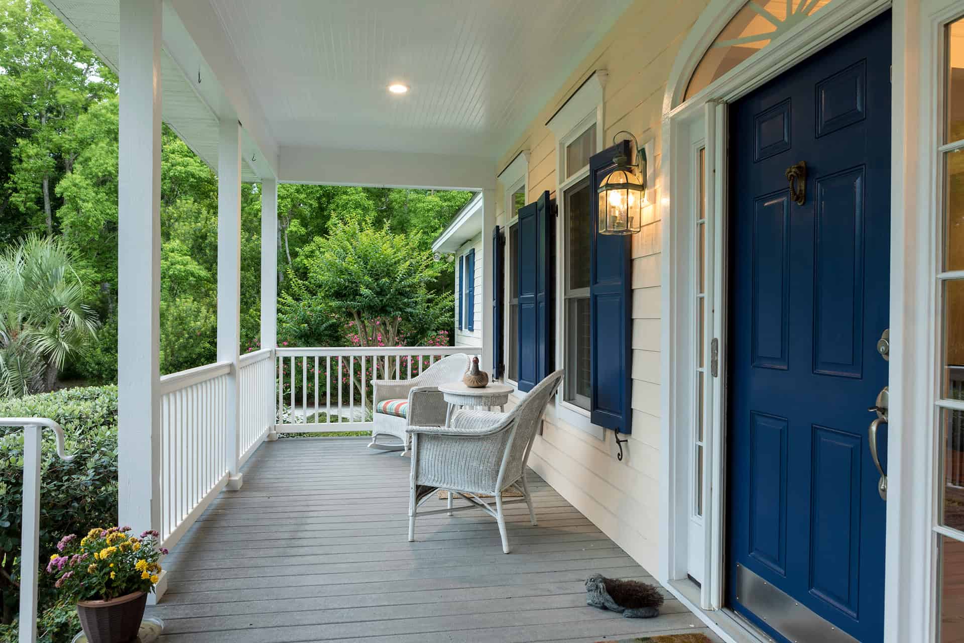 Covered front porch with seating and blue doors.