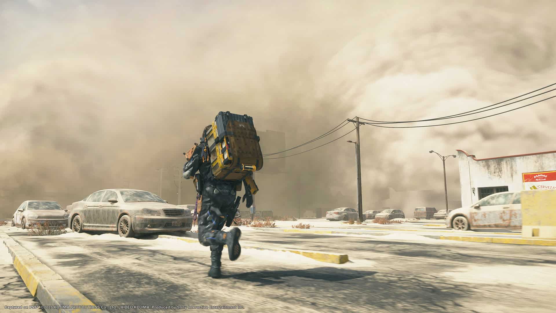 Death Stranding 2 On The Beach screenshot with Sam running through a dust storm