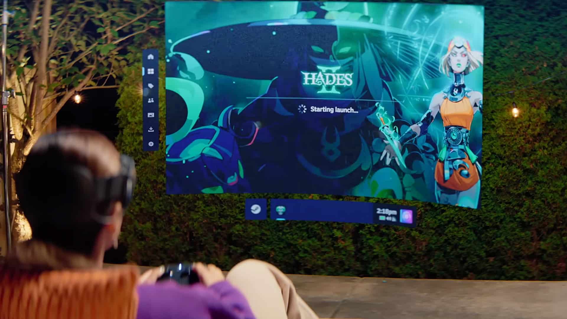 Woman playing on a Steam Frame with Hades 2 projected in front of her