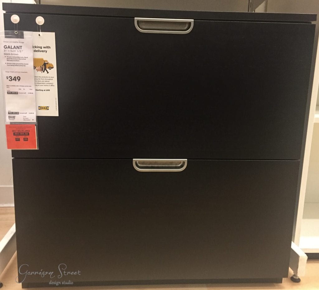A dark wood cabinet with two drawers and silver handles graces the store, its price tags neatly affixed to the top left corner. As part of IKEA's Galant series, it's perfect for your next IKEA desk hack project.