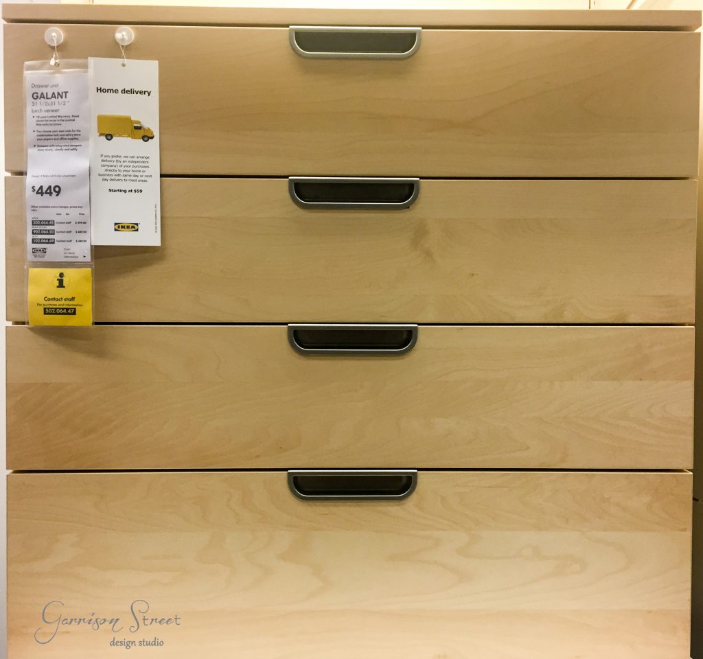 A light wood dresser with four drawers, each featuring black handles, offers a touch of style to any room. Two informational tags hang from the upper left corner, with one showing a price of $449 and another indicating home delivery options—perfect for those exploring an IKEA desk hack.