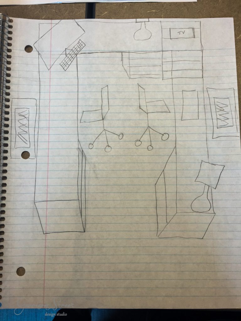 A hand-drawn sketch on lined notebook paper depicts a room layout featuring a clever IKEA desk hack with a large L-shaped desk, two office chairs, a TV, and several rectangular objects that might represent furniture like cabinets or tables.