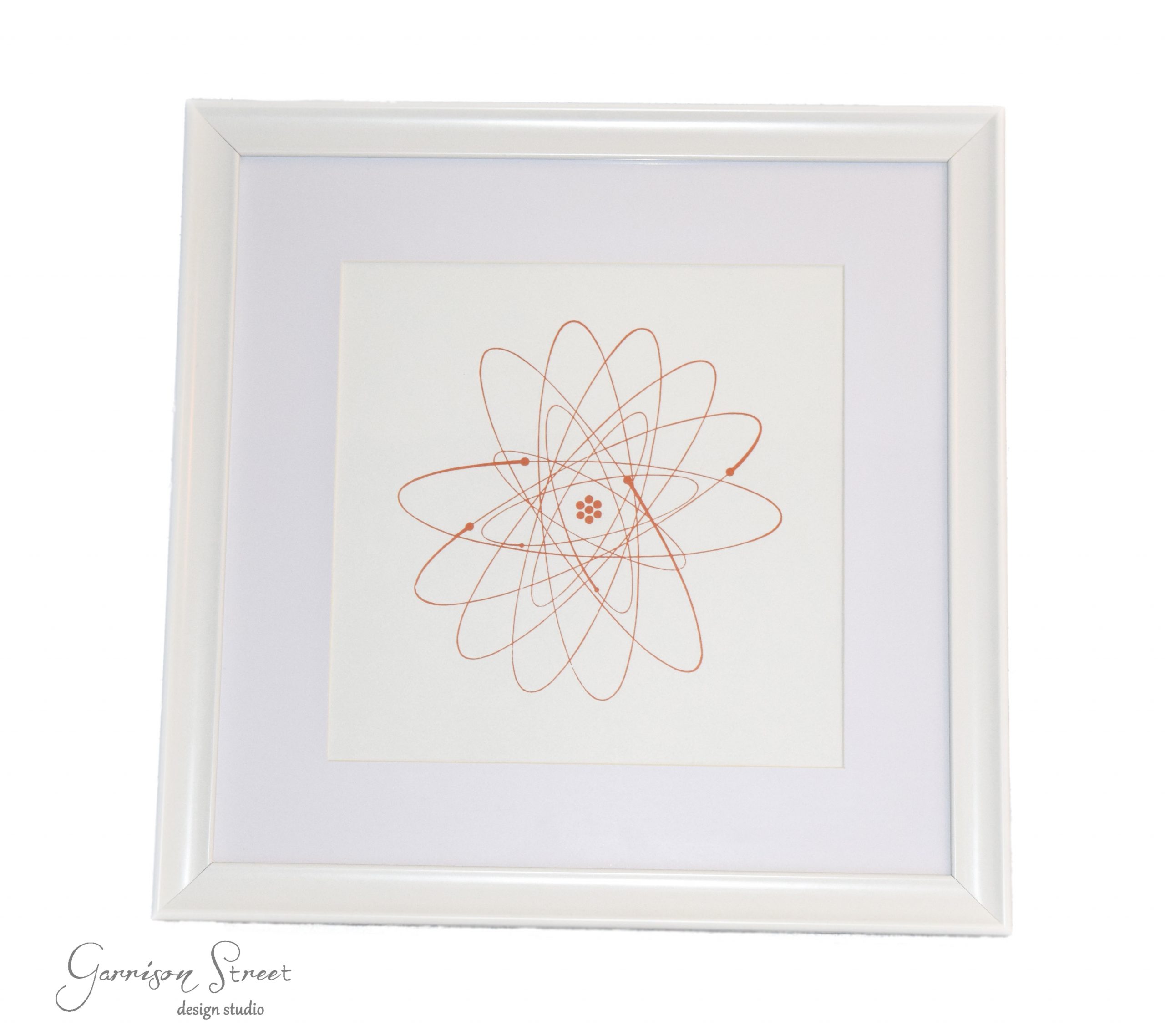 A white-framed picture featuring an intricate geometric design with overlapping loops in a radial pattern. The background is white, and the design is in a subtle peach color.