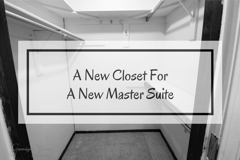 Black and white photo of an empty walk-in closet with shelving and hanging rods. Text overlay reads "A New Closet For A New Master Suite.