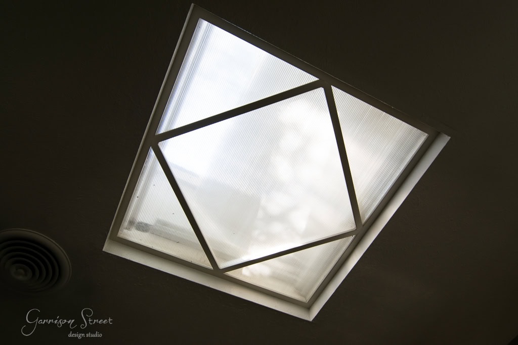 A kitchen skylight with geometric patterns graces the ceiling, allowing diffused natural light to fill the space. Nearby, a circular air vent complements the design.