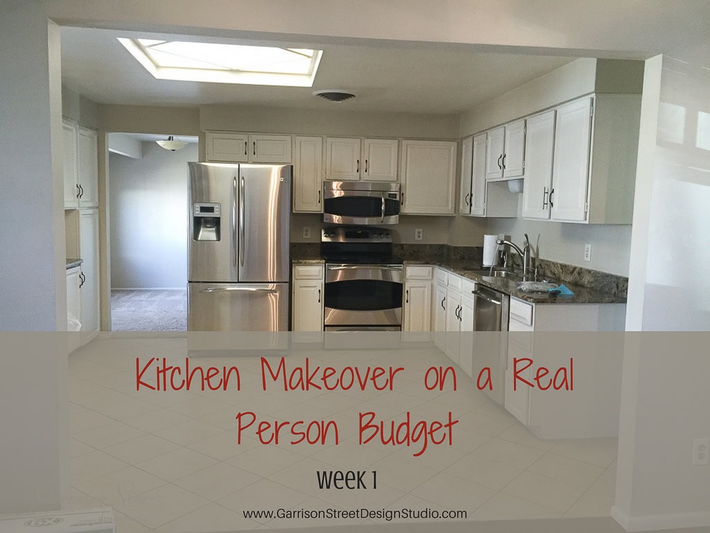 A modern kitchen with stainless steel appliances, white cabinets, and a tile floor. The text on the image reads, "Kitchen Makeover on a Real Person Budget, week 1.