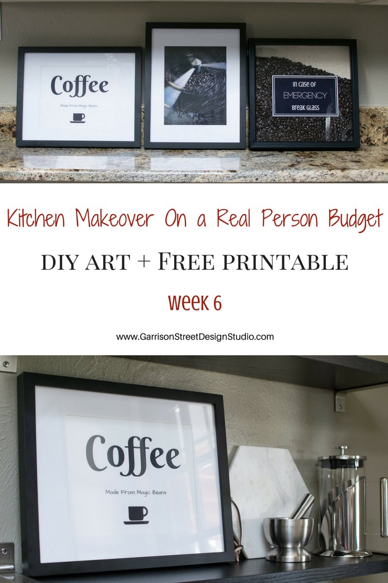 A display of framed coffee-themed artwork on a shelf. One frame reads "Coffee Made From Magic Beans," and another says, "In Case of Emergency Break Glass" with coffee beans. Nearby, a coffee pot and accessories on the counter.